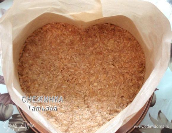 На дно утрамбовываем получившееся тесто, формируя корж.