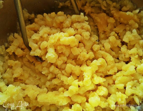 Далее слить картофель и размять толкушкой.
