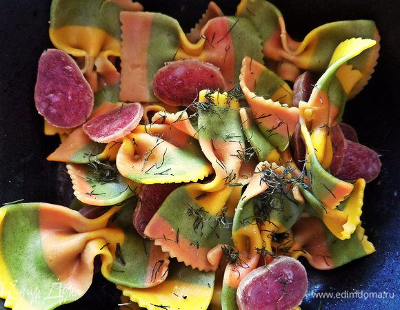 Отправляем колбасу к пасте, добавим укроп или другую зелень.