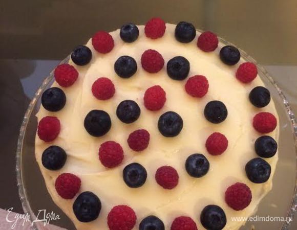 Накрыть второй половиной бисквита. Смазать кремом, украсить малиной и черникой.