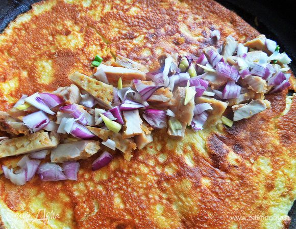 В центр омлета разложит курицу с луком.