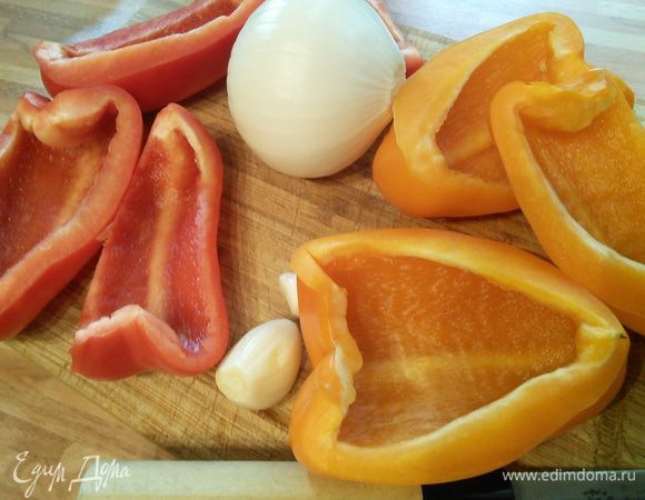 Лук и чеснок очистить, порубить и обжарить на разогретом масле до прозрачности. Добавить нарезанный полосками перец и обжарить в течении 5 мин. 