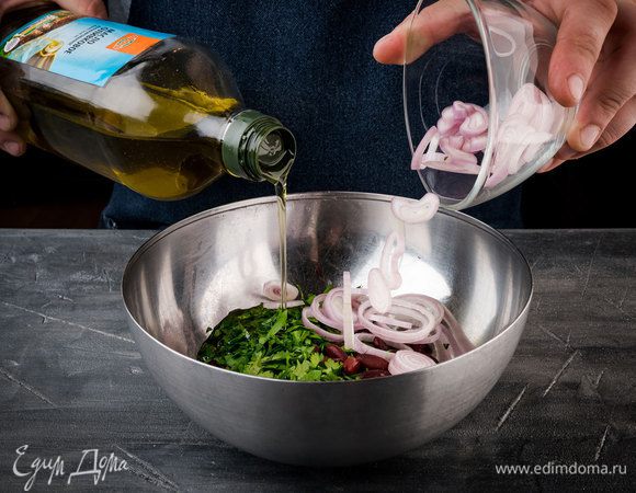 Фасоль соединить с луком, петрушкой и кинзой. Влить оливковое масло, поперчить и перемешать.
