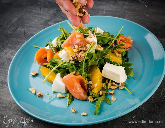 Все оставшиеся ингредиенты выложите на руколу, сбрызните лимоном и добавьте масла. И последний штрих — посыпьте раздробленными грецкими орехами. 