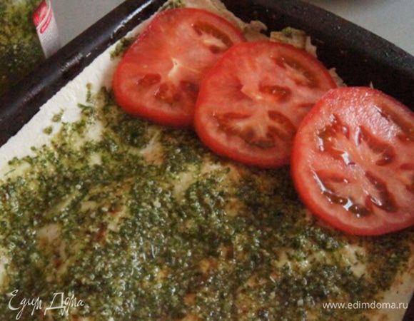 Снова накрыть листом лаваша. Смазать равномерно соусом песто. Используйте готовый или сделайте соус сами. Сверху выложить нарезанные на кружочки помидоры.