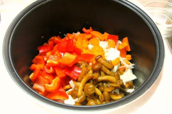 К мясу в чашу выложить морковь, перец, лук, грибы, перемешать.