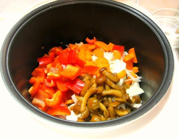 К мясу в чашу выложить морковь, перец, лук, грибы, перемешать.