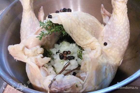 Слить маринад, нафаршировать курицу луком и тимьяном. Закрепить зубочисткой отверстие и запекать курицу в заранее разогретой до 200°С духовке приблизительно 1,15 — 1,30 часа.