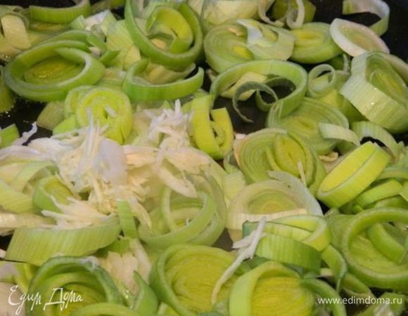 Лук-порей нарезаем кольцами, чеснок через пресс. Выкладываем на раскаленную сковороду. И обжариваем несколько минут.