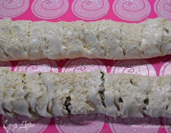 Поднимать полоски на верх поочередно, чтобы получилась плетенка, края с двух сторон защипить, чтобы не вытек сок. Смазать плетенку взбитым яйцом и по желанию посыпать кунжутом. Выпекать пирог в предварительно разогретой духовке, при 180°C, 25-30 минут.