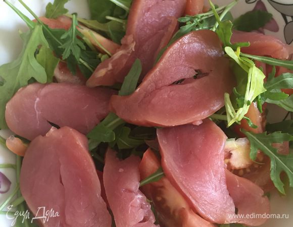 Выкладываем на тарелку руколу, порезанные помидоры и грудинку.