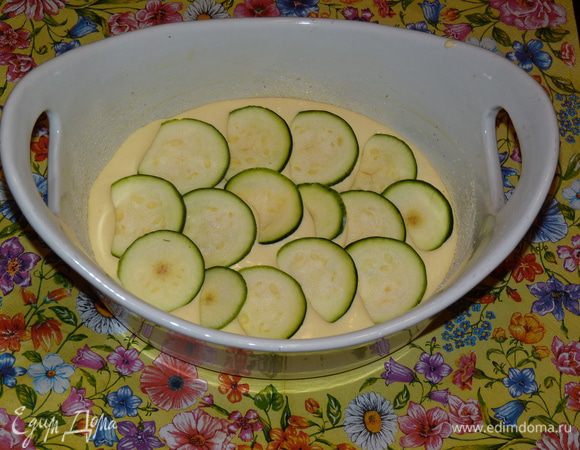Половину творожной массы выложить в форму. Сверху выложить кружки цукини.