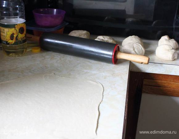 Разделить тесто на 6-10 частей. У меня 8.
Одну берем, раскатываем примерно до 0,5 см толщиной, смазываем маслом.
Раскатываем вторую и укладываем ее на первую и снова смазываем маслом.
Таким образом укладываем по очереди все слои, верхний маслом не смазываем.