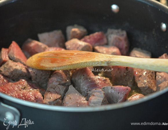 Говядину нарезать кубиками, посолить, поперчить.
Обжарить со всех сторон на масле оливковом и сливочном. Переложить на тарелку.