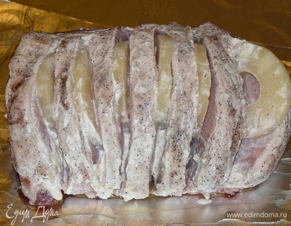 Фольгу смазать оливковым маслом. Выложить на фольгу мясо, вставить в «кармашки» по колечку ананаса.