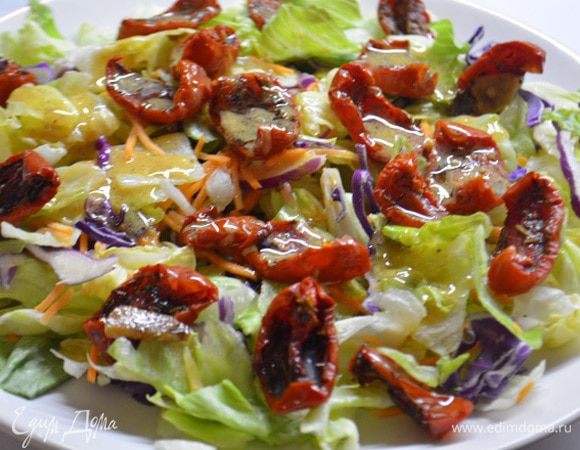 На широкую тарелку выложить салатный микс, вяленые томаты. Смешать заправку: растительное масло, горчица, сок половины лимона, соль и свежемолотый перец. Полить заправкой салатные листья и перемешать.