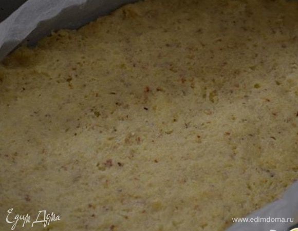 Форму застелить пекарской бумагой и выложить тесто, разровнять по форме.