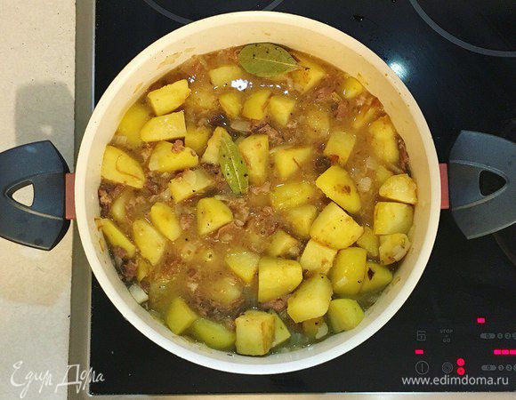 Добавить тушенку (без белого жира), перемешать, положить лавровый лист, посолить, поперчить по вкусу. С солью осторожнее, потому что тушенка уже сама соленая. Убавить огонь до минимума, накрыть крышкой, готовить еще около 30 мин. Если жидкости маловато, то можно добавить немного воды. 
Перед подачей посыпать свежим укропом. Приятного аппетита !