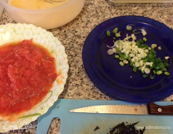 Яйца слегка взбить венчиком. Лук, чеснок и зелень мелко нарезать. С помидора снять шкурку и натереть на крупной терке.