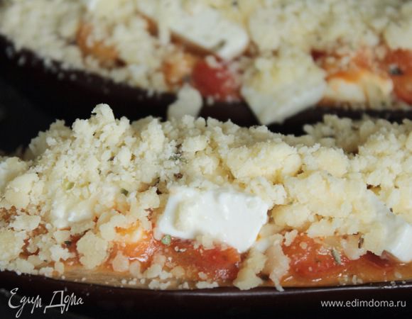 В лодочки баклажана выложить смесь из томатов и баклажана, сверху фету. Затем обильно присыпать крошкой из теста.