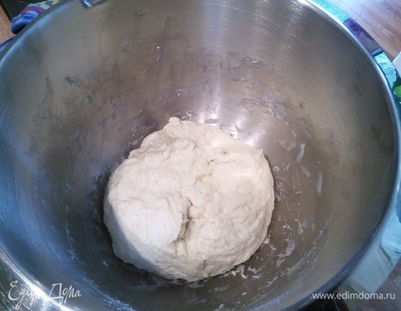 Смешать в миске муку с солью, дрожжи развести в теплой воде и оставить на 15 минут для активации. После того, как появилась характерная «шапочка», влить дрожжевую воду в муку и размешать. Вымешивать не надо, размешать деревянной ложкой до гладкого, однородного теста. Накрыть пленкой и оставить на 2 часа на расстойку. За это время каждые 30 минут обмять. 