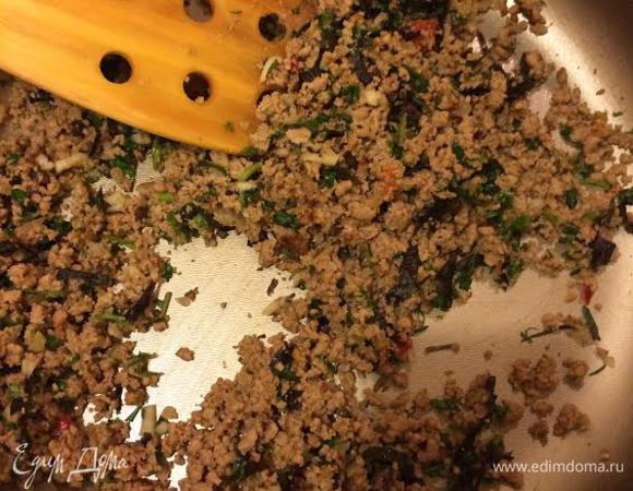 Добавить аджику, зелень, чеснок и немного воды, в которой варились макароны, и потушить 3 — 4 минуты.