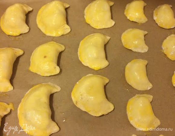 Пирожки выложить на противень. Желток смешать с молоком и смазать пирожки.