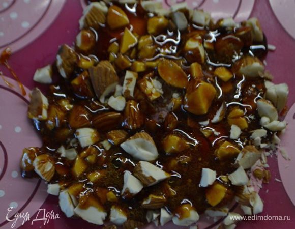 В сотейник всыпать сахар и нагреть до карамельного цвета (так как мы делали для желейных шариков), растопленный сахар вылить на орехи, остудить.