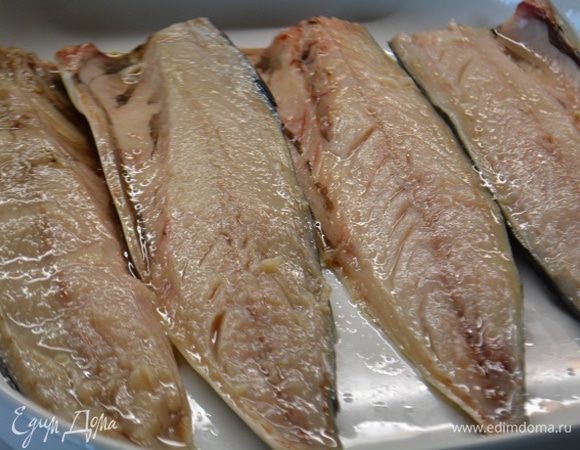 Скумбрию разделить на филе, лучше всего это делать когда рыба подморожена. Выложить в форму шкурой вниз и сбрызнуть соком лимона.