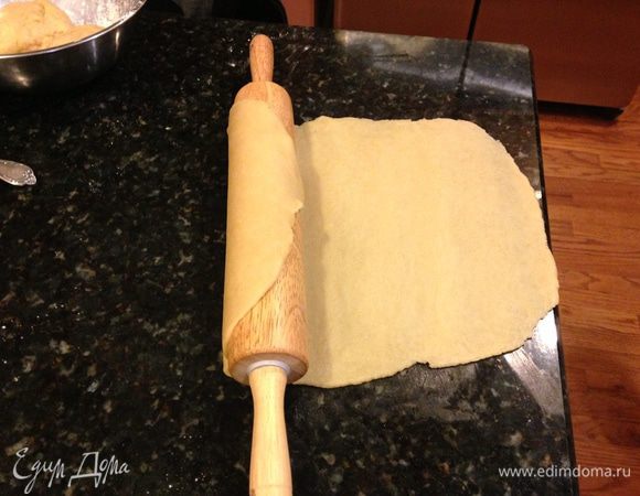 Разделить тесто на 3 части, первая должна быть чуть больше двух остальных,  чтобы защипывать края. Раскатать первый слой и накрутить его на скалку.