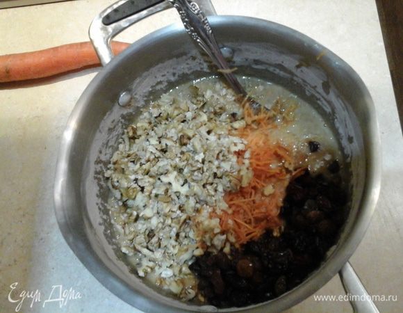 Добавить тертую морковь, рубленные грецкие орехи и изюм. Все хорошо перемешать.