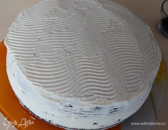 Накрыть вторым коржом. Торт сверху и с боков обмазать кремом, отложив небольшое количество для декора.