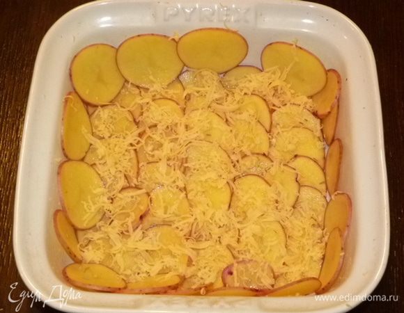 Натереть сыр на терке. Разделить на 5 частей. Одной частью посыпать картофель, остальной сыр пригодится для следующих слоев. 