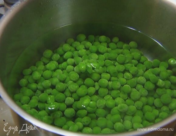 Зеленый горошек предварительно разморозить, затем отварить в кипящей воде до мягкости (но не переварить!), воду слить в другую кастрюлю.