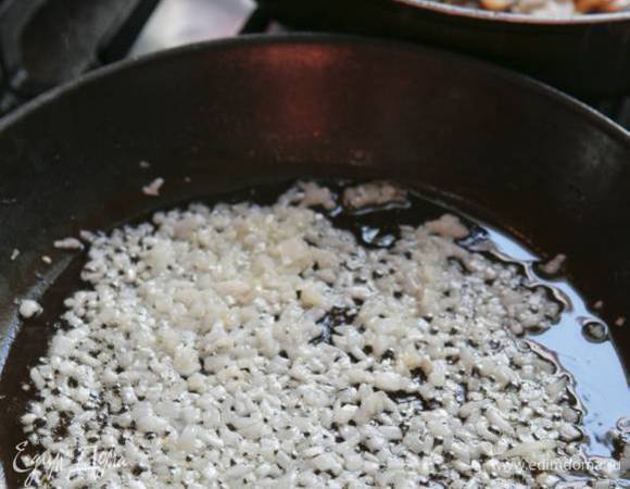 В отдельной сковороде разогреть 100 г сливочного и оставшееся оливковое масло и довести лук до прозрачности.