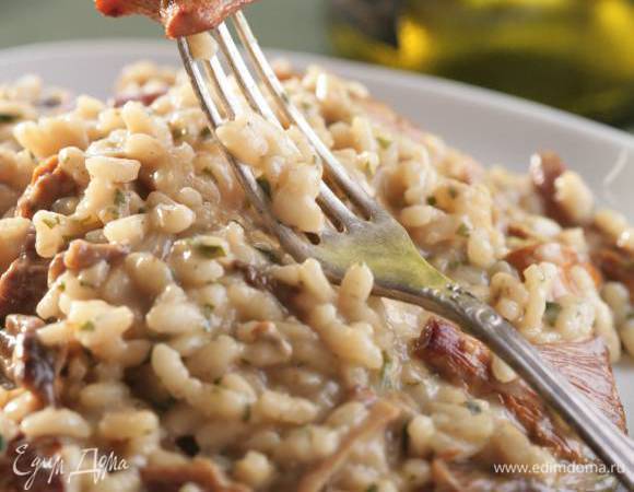 Когда рис будет готов, добавить обжаренные грибы с чесноком, оставшееся сливочное масло, натертый сыр и измельченную петрушку.