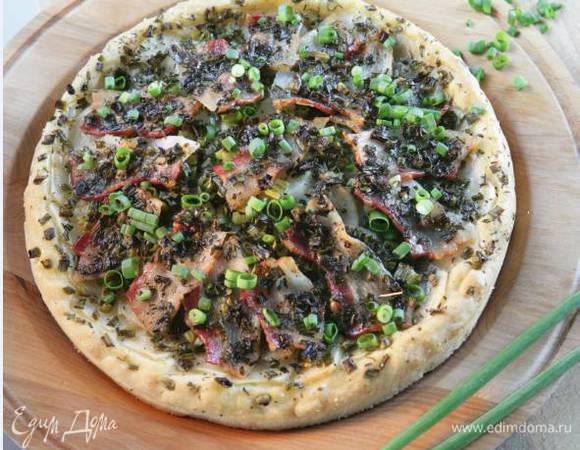 Раскатать тесто в тонкий пласт, уложить на противень, сверху разложить лук, картофель и бекон, сбрызнуть оставшимся оливковым маслом.