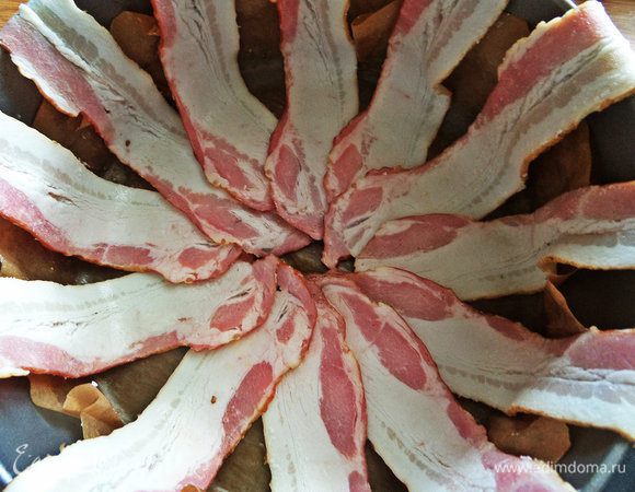 Съемную форму застелить пергаментом и разложить ломтики бекона на расстоянии.