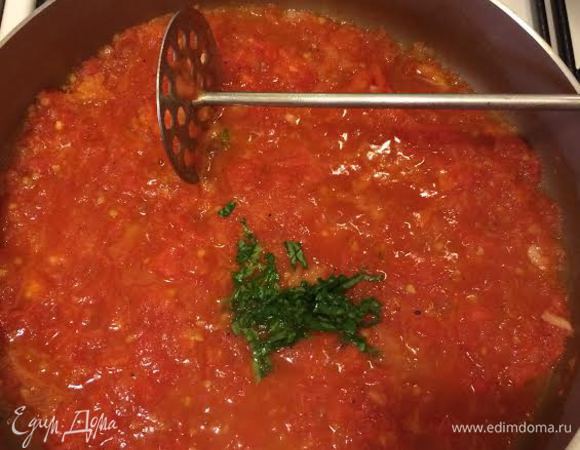 Помидоры помять прессом для картофеля, добавить базилик и тушить на слабом огне 15 минут.