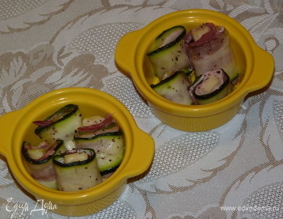 Огнеупорную форму смазать сливочным маслом, выложить рулетики. Посыпать паприкой и смесью перцев. Запекать в разогретой до 160°С духовке 15 минут.