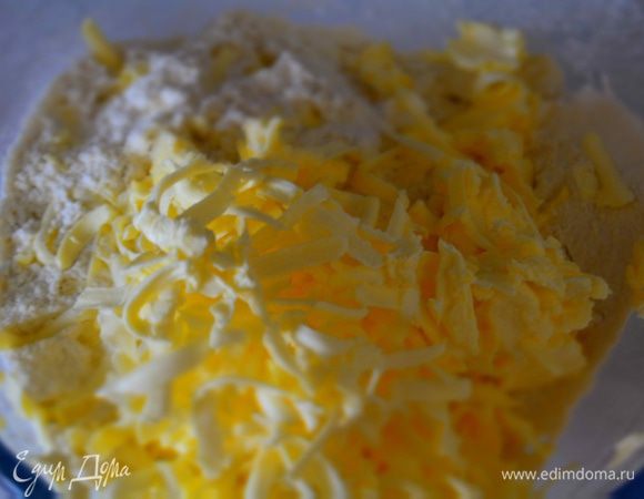 В миску просеять муку, ванилин и разрыхлитель. Всыпать сахар. Потереть туда же масло холодное на крупной терке. Растереть массу в крошку. 