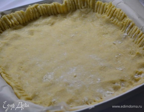 Достаем тесто. Отщипываем 1/3 и убираем обратно. Остальное тесто раскатать на пекарской бумаге и перенести в форму. Сформировать бортики.