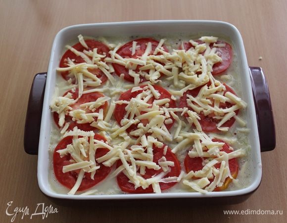 Сверху уложить кружочки помидора и посыпать сыром.
