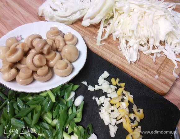 Капусту моем, шинкуем. Грибы моем, если крупные — режем на половину. Зеленый лук — колечками. Чили освобождаем от семян и перепонок и режем колечками. Чеснок и имбирь чистим, мелко крошим. 