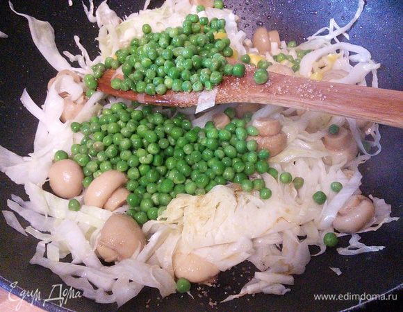 На сковороде разогреваем масло, выкладываем капусту и шампиньоны и жарим на большом огне 3 — 4 мин, добавляем имбирь, чеснок, чили, сахар и зеленый горошек и обжариваем еще 2 мин. 