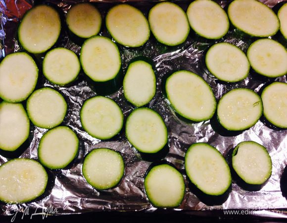 Порезать цукини колечками и выложить на противень.