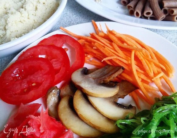 Подготовить продукты: приготовить кускус, отварить макаронные изделия, поджарить грибы, кунжут, нарезать помидор, морковь натереть на «корейской» терке.