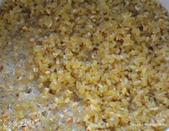 В кастрюле разогреть сливочное масло и 2 ст. л оливкового масла. Всыпать булгур и обжарить, помешивая, 3 — 4 минуты. Залить крупу горячей водой и варить до готовности под закрытой крышкой (это около 45 минут).