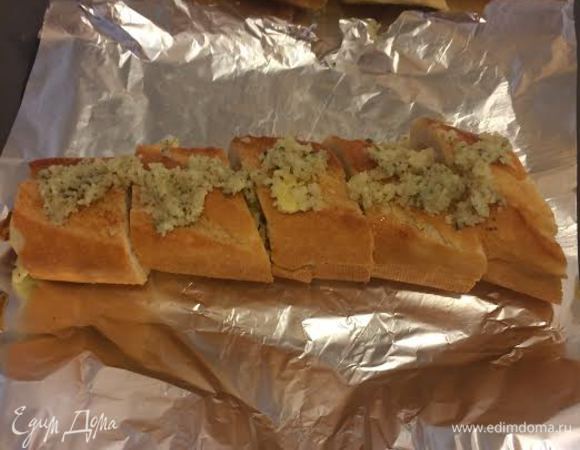 Багеты выложить на фольгу, нарезать на порционные куски. Сверху выложить смесь из пармезана.