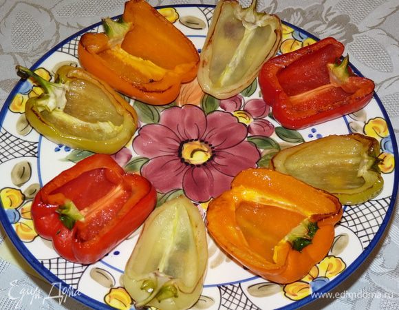 На лист духовки растелить бумагу для выпечки. Смазать оливковым маслом и выложить перцы срезом вниз. Выпекать в заранее разогретой до 180°С духовке 5 мин., Затем перевернуть и запекать 3 минуты. 